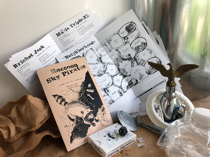 The Raccoon Sky Pirates zine, play sheets, Deck of Complications and raccoon die